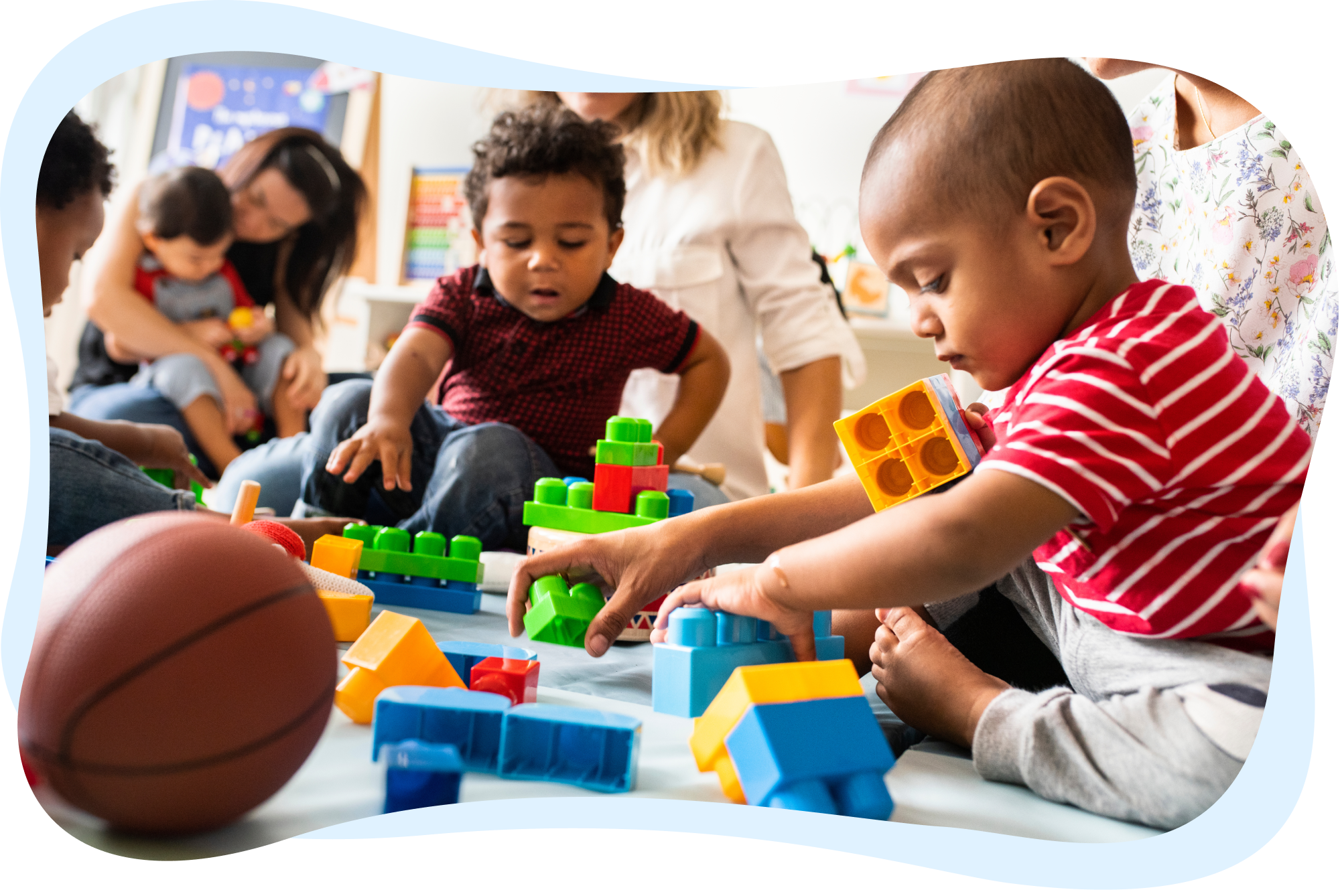 A group of young children playing with colorful blocks on the floor.